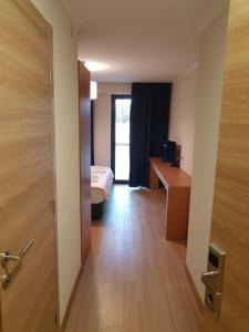 Cette chambre comprend un lit, un bureau et une porte. dans l'établissement Dima Orbi apart. Bakuriani, à Bakuriani
