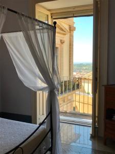 a bedroom with a bed with a view of a balcony at Town View in Noto +46 photos