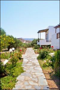 un sentiero in pietra in un giardino accanto a una casa di Casa di Mare a Paleocastro (Palekastron)