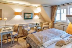 Cette chambre comprend un lit, un bureau et des chaises. dans l'établissement Landhotel Restaurant zur Krone, à Gottenheim