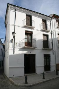 a white building with two balconies and a door at Casa Rural Villalta in Priego de Córdoba