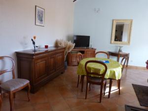 ein Wohnzimmer mit einem Tisch, Stühlen und einem TV in der Unterkunft La Campagnarde in Saint-Just-en-Chevalet