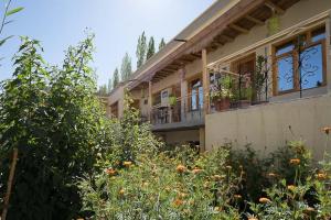 un bâtiment avec un balcon et quelques buissons dans l'établissement Siala Guest House, à Leh