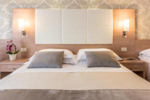 a bedroom with a large white bed with two pillows at Michelangelo Cesenatico in Cesenatico