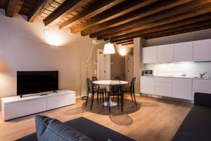 a living room with a table and a kitchen at MyPlace Padova Centro Storico in Padova