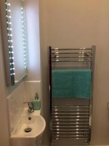a bathroom with a sink and a green towel at Lismore Guest House in Whitehaven