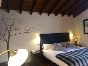 una camera da letto con un letto con uccelli sul muro di El Coto Hotel Restaurante a Vitoria-Gasteiz