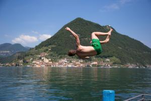 
a person jumping in the air over a body of water at Hotel Rivalago in Sulzano
