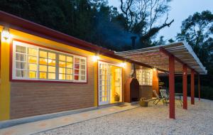 una pequeña casa con luces en el lateral. en Pousada Chalés da Casa Centenária, en Santo Antônio do Pinhal