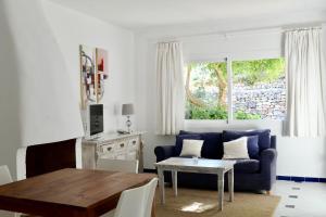 a living room with a blue couch and a table at Hacienda Encanto del Rio in Santa Eularia des Riu