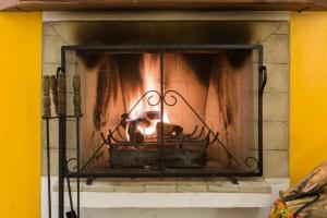 a fire in a fireplace with a person in it at Pousada Chalés da Casa Centenária in Santo Antônio do Pinhal