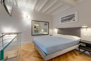 ein Schlafzimmer mit einem großen Bett und einem Spiegel in der Unterkunft TAILOR HOUSE B&B in Florenz
