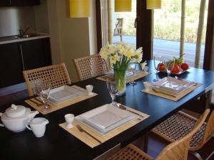 a dining room table with plates and flowers on it at Apartament Bornholm in Jurata