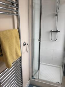 a bathroom with a shower with a yellow towel at The Bridge View in Runcorn