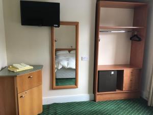 a bedroom with a mirror and a bed and a television at The Bridge View in Runcorn