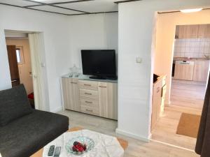 a living room with a couch and a flat screen tv at Haus auf der alten Düne 2 in Prerow