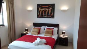 聖瑪麗亞的住宿－Private Apartment At Tortuga Beach Resort and Spa，一间卧室配有红色和白色的床,设有2个床头柜