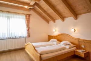 a bedroom with a wooden bed in a room at Garnì Lasteis B&B - apartments in La Villa