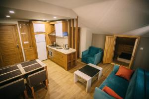 a living room with a blue couch and a kitchen at Turkuaz Apart in Uzungöl