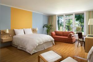 ルクセンブルクにあるホテル パルク ベルビューの大きなベッドと椅子が備わるホテルルームです。