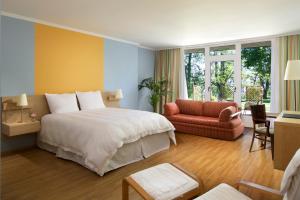 a hotel room with a large bed and a chair at Hotel Parc Belle-Vue in Luxembourg