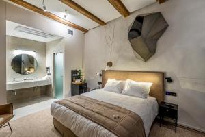 
a bedroom with a large bed and a large mirror at Artagonist Art Hotel in Vilnius
