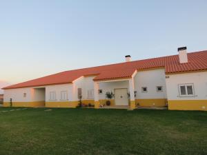 a house with a red roof and a yard at Quinta da Caldeireira in Rosmaninhal
