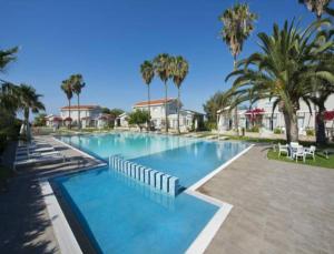 una gran piscina con palmeras en un complejo en Mon Repos Hotel en Ayia Napa