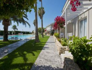 a sidewalk next to a house with a swimming pool at Mon Repos Hotel in Ayia Napa