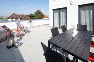 d'une terrasse avec une table et des chaises en bois sur un balcon. dans l'établissement Penthouse-Appartements Freiburg, à Fribourg-en-Brisgau