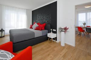 ein Schlafzimmer mit einem Bett mit roten Kissen in der Unterkunft Penthouse-Appartements Freiburg in Freiburg im Breisgau