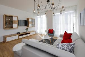 - un salon avec un canapé et des oreillers rouges dans l'établissement Penthouse-Appartements Freiburg, à Fribourg-en-Brisgau