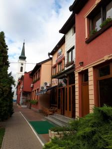 une rue dans une ville avec une tour d'horloge en arrière-plan dans l'établissement Business Club Selenča, à Bač