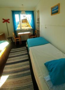 1 dormitorio con 2 camas, mesa y ventana en Storliens Fjällgård en Storlien