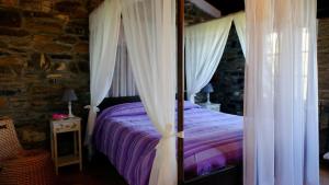 a bedroom with a bed with white curtains at Agriturismo il Roccolo in Pantasina