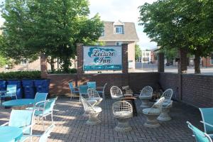 a patio with chairs and tables and a sign at Leisure Inn in Haileybury