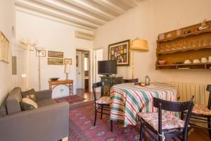 un soggiorno con tavolo e divano di Typical Florentine Apartment a Firenze