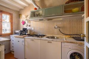 una cucina con lavandino e lavatrice di Typical Florentine Apartment a Firenze