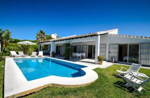 a villa with a swimming pool in front of a house at Great Villa Near Beach and Marbella in Marbella