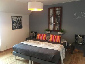 a bedroom with a bed with colorful pillows on it at Madinina'S Cube in Saint-Aignan