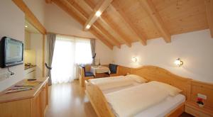 a bedroom with a bed and a tv in a room at Garnì Lasteis B&B - apartments in La Villa