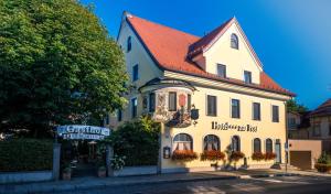 慕尼黑的住宿－嘎斯霍夫祖爾博斯特酒店，街道上白色的建筑,有红色的屋顶
