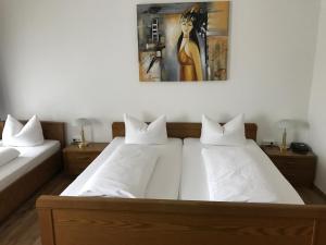a bedroom with two beds and a painting on the wall at Hotel Rheinischer Hof in Geldern