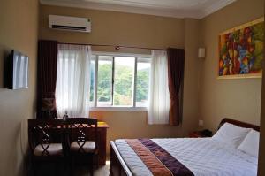 un dormitorio con una cama y una ventana en Ngoc Chau Phu Quoc Hotel, en Phu Quoc