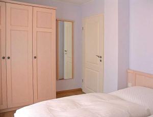 プレローにあるFerienhaus Sundevit Nr 1 Prerowのベッドルーム(白いベッド1台、鏡付)