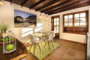 a dining room with a table and chairs at Los Charcones vivienda vacacional in Playa Blanca