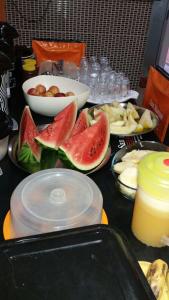 uma mesa coberta com pratos de frutas e alimentos em Hotel San Marino em Goianésia