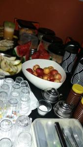 a table topped with a bowl of fruit and glasses at Hotel San Marino in Goianésia
