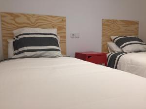 a bedroom with two beds and a pillow at Suites La Catedral in León