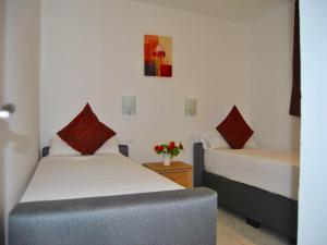a bedroom with two beds and a table with flowers at Aparthotel MONTERREY in Puerto Rico de Gran Canaria +82 photos